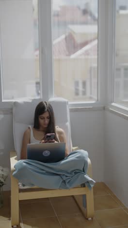 young woman working from home on balcony