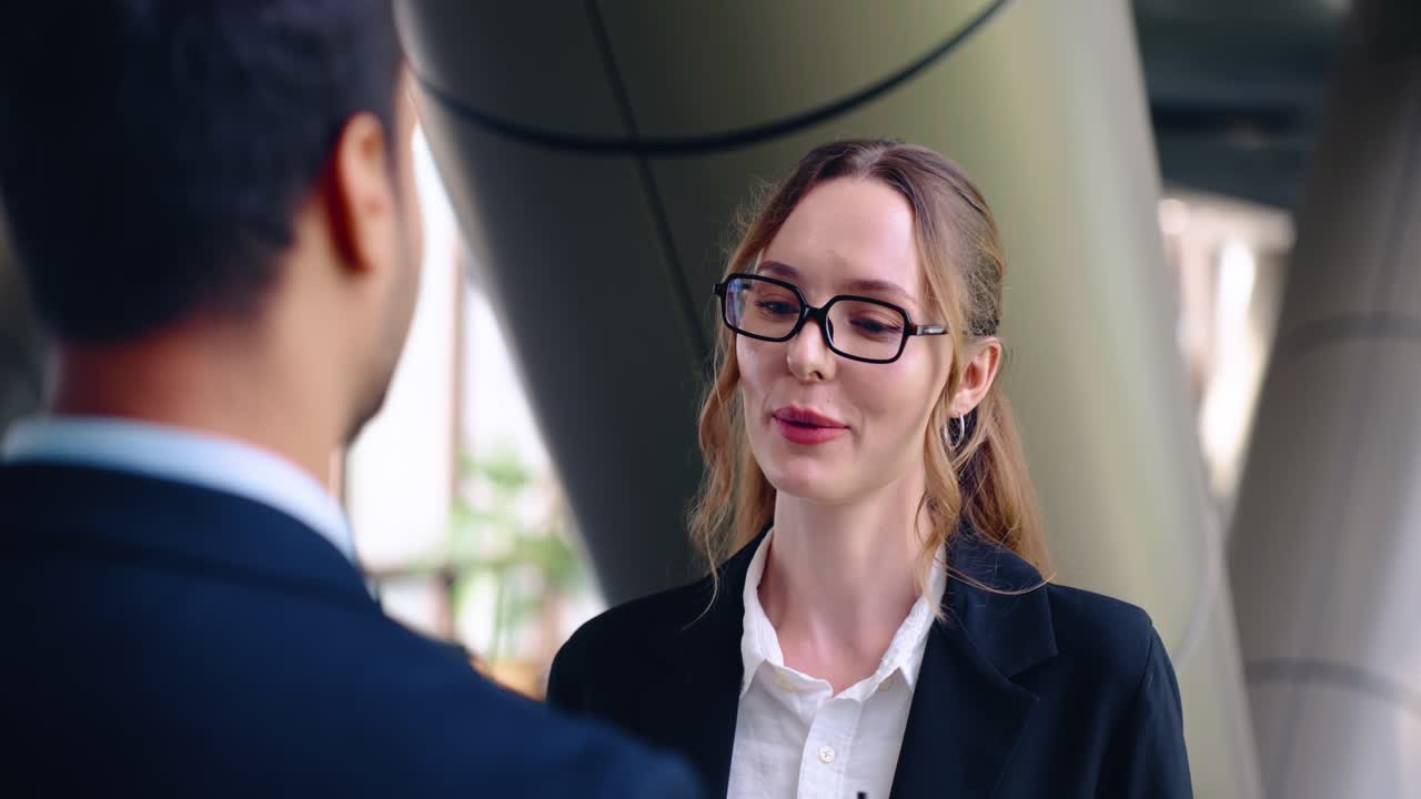 Caucasian Businesswoman In Glasses Smiles At Her Male Colleague During A Conversation In The Office. - closeup shot
