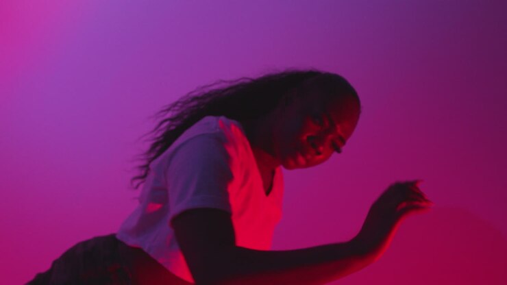 Studio Shot Of Young Woman Dancer Dancing Against Blue And Pink Lit Background 3