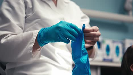 un dentista poniendo guantes de goma preparándose para una limpieza de dientes