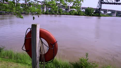 a life raft hangs on a post along the cuyahoga river