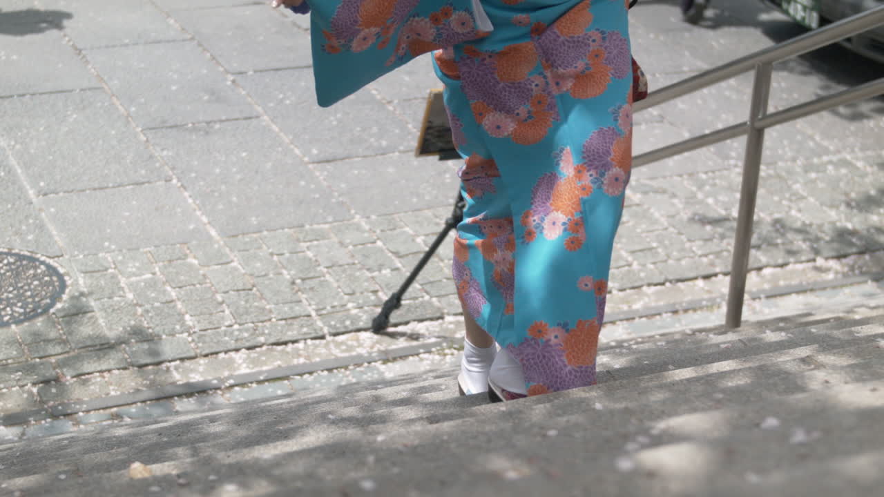 Woman in beautiful blue Kimono walking up stairs (50p)