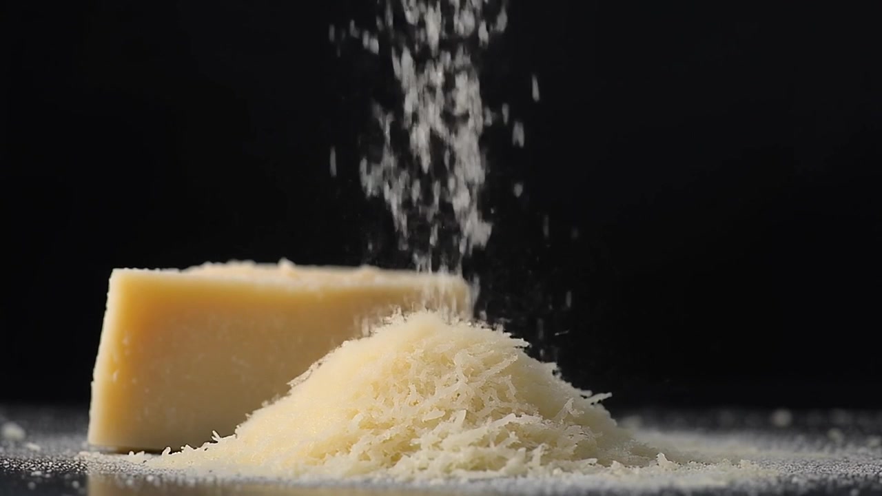 Fromage parmesan râpé tombant sur un tas