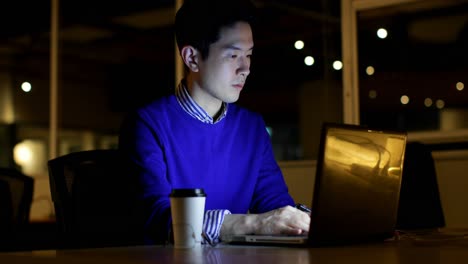 male executive using laptop at desk in office 4k