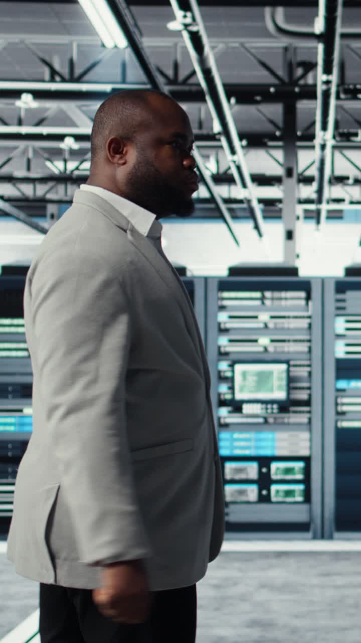 Vertikal video Systemadministrator går i datacenter med serverracks, der udfører sikkerhedskopiering