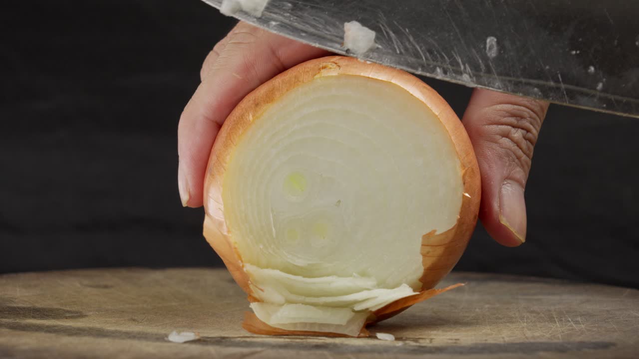 Nahaufnahme, Messer schneidet frische Zwiebel auf Schneidebrett, Koch-Tutorial.
