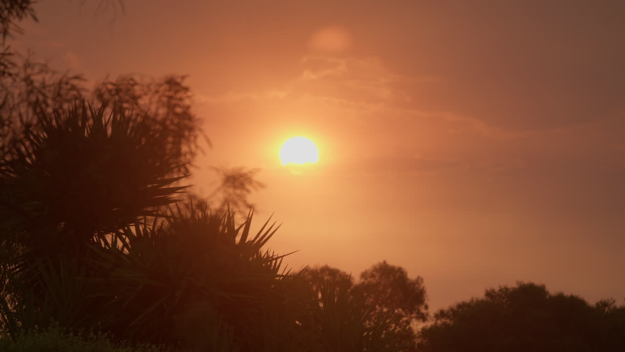 Soleil rouge ardent avec un paysage crépusculaire enfumé en fin d’après-midi