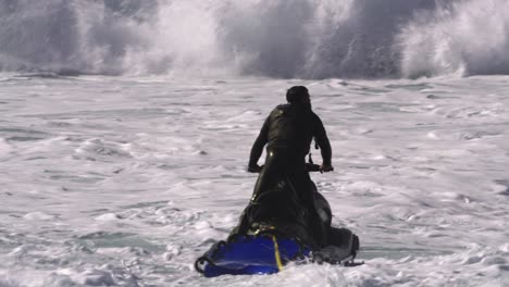 Der-Jetski-Fahrer-Pflügt-Durch-Eine-Flutwelle-Aus-Schaum,-Die-Ihn-In-Die-Luft-Trägt