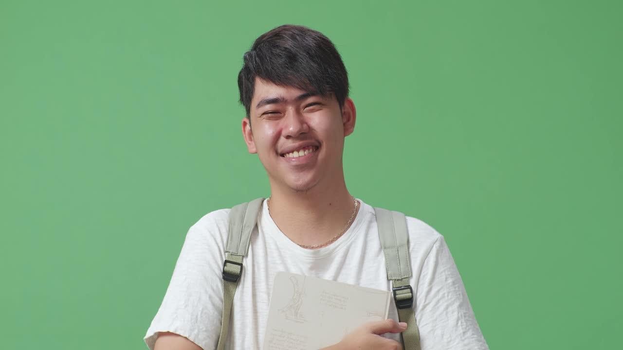 책 을 들고 미소 짓는 학생