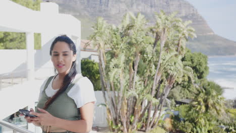 holding smartphone, mature asian woman enjoying spa with scenic mountain view, balcony, copy space