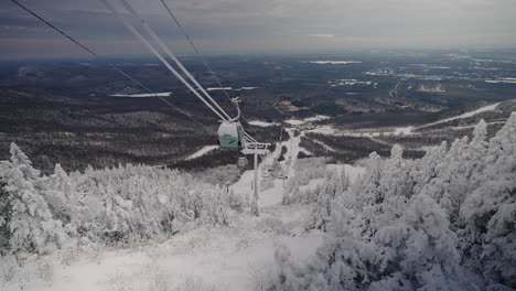 the winter scene in mont orford quebec canada surrounded with snowy trees with cable car during nighttime - aerial shot