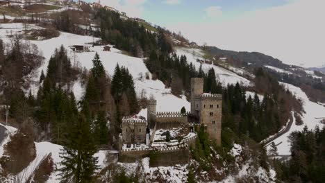 Beautiful-reveal-of-Gernstein-Castle-located-in-the-Dolomites,-during-winter-time