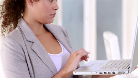 Pregnant-businesswoman-using-her-laptop