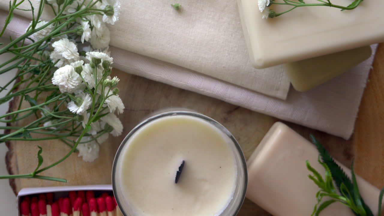 Close up of white candles and soaps on a wooden surface
