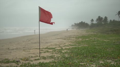 rote fahne weht am strand, filmische aufnahme, wellen im hintergrund