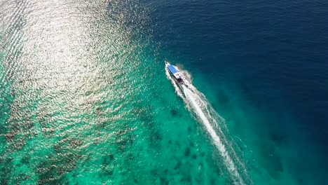 Indonesisches-Touristenboot,-Das-über-Korallenriffe-In-Richtung-Sonne-Segelt