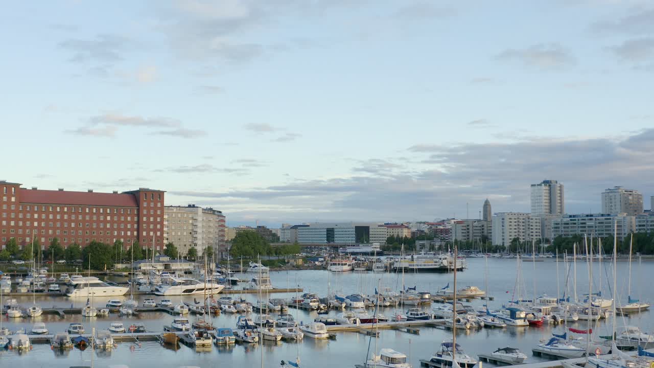 panorámica aérea lenta de barcos pequeños y grandes en un muelle a lo largo de la costa de helsinki, finlandia