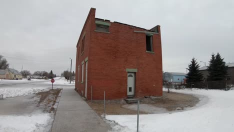 un viejo edificio de ladrillo abandonado en un pequeño pueblo durante el invierno cerca de alberta, canadá