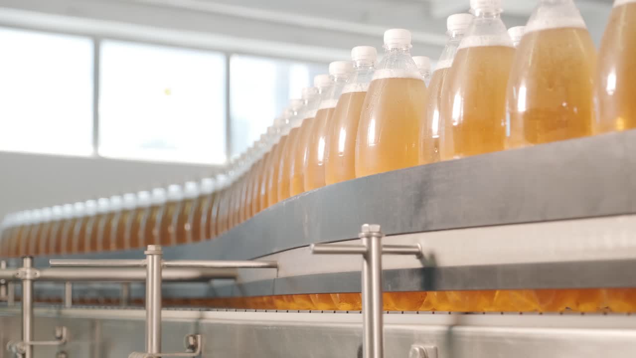 cinta transportadora con botellas para jugo o agua en una planta moderna de bebidas. producción moderna de agua dulce soda