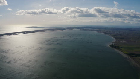 Aerial-view-of-the-Bassin-de-Thau-sunny-day-with-clouds-Marseillan-and-Agde