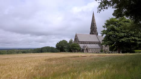 UK-church-and-steeple-overlooking-hayfield-village-and-tree-lined