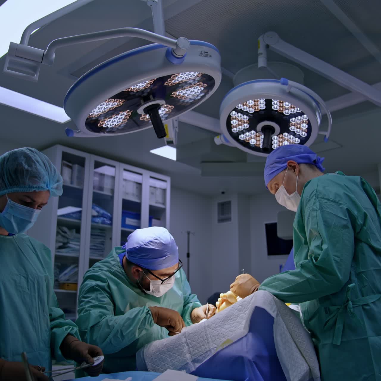 Surgical procedure on the foot in modern clinics. Two surgeons and nurse performing the operation