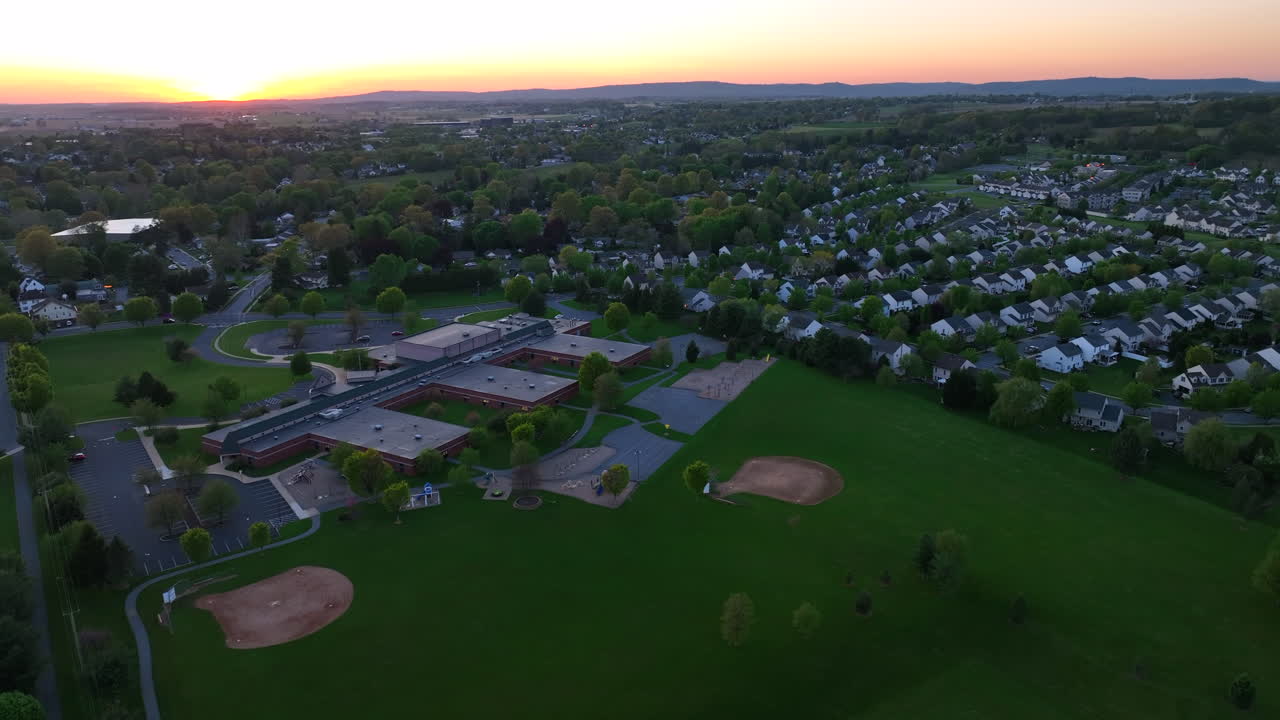 High aerial establishing shot of neighborhood and school