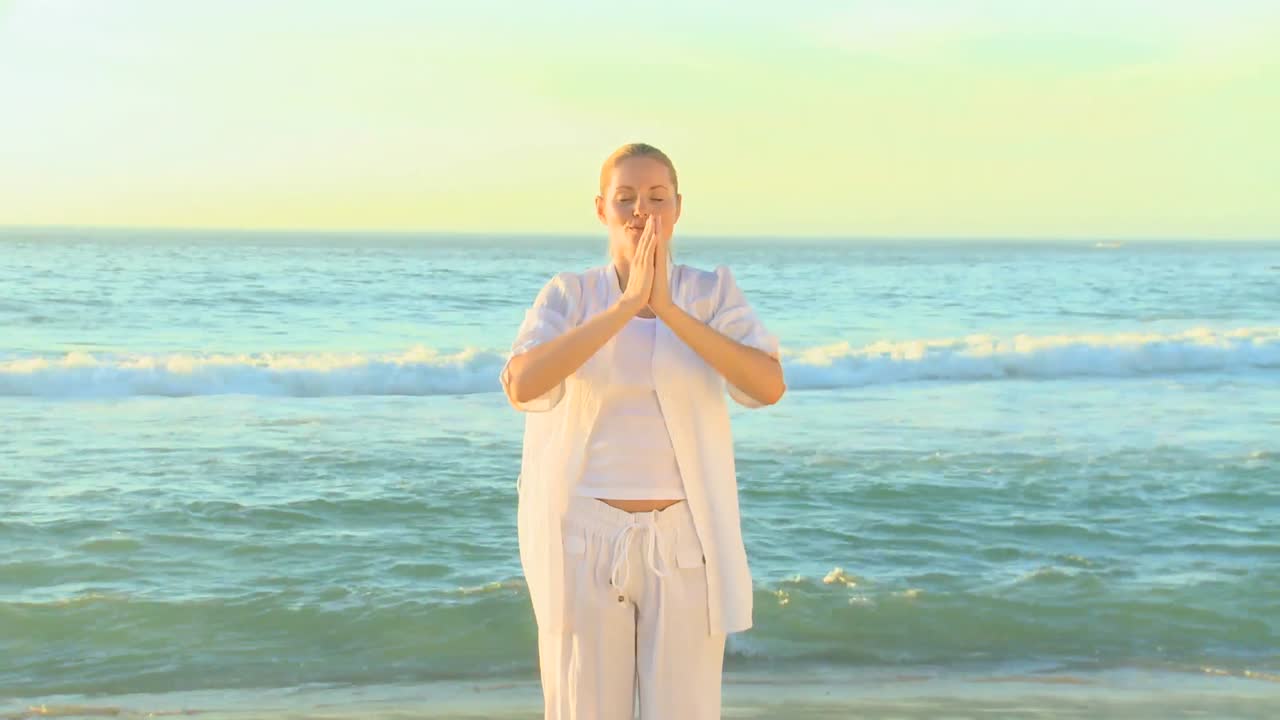 해변 에서 요가 를 하는 여자