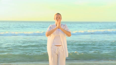 donna che fa yoga su una spiaggia