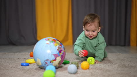 baby playing with toys and a globe