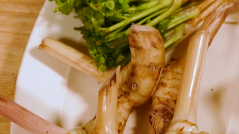 Galangal-and-Coriander-Root-on-White-Plate,-Close-Up-2