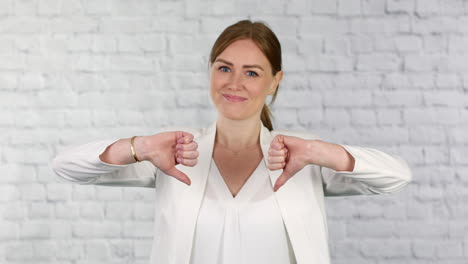 a young business woman gives shows her disapproval with a thumbs down gesturing a no