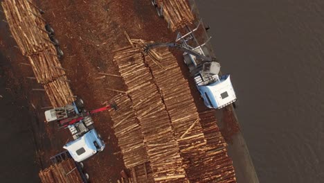 forestry and logging operations taking place in the highlands of scotland using large industrial machinery, ships and trucks