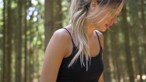 Pretty-woman-with-long-hair-finishes-her-run-and-sits-down-to-drink-from-a-bottle-of-water