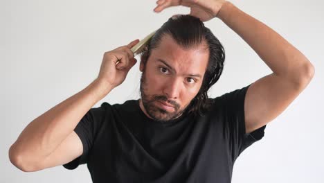 man-using-brush-on-his-head-with-baldness,-Hair-strands