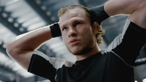 sexy sportsman touching hair in sport club. fighter thinking about fight at gym