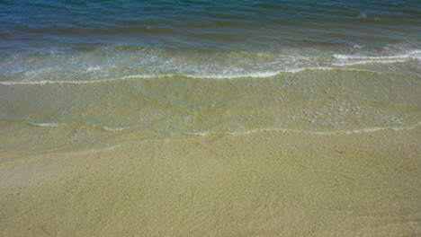 la cámara se inclina hacia arriba desde relajarse escrito en la arena de una playa hasta el horizonte mostrando el océano
