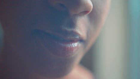 primer plano de la boca y los labios con brillo, chica afroamericana sonriendo cara detalle cinematográfico fotograma completo