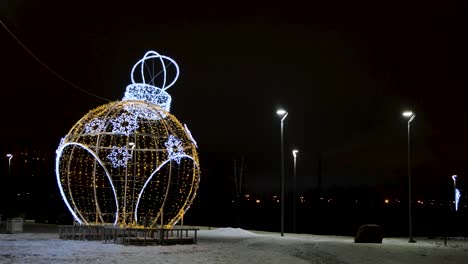 gigante ornamento de navidad iluminado en un parque por la noche