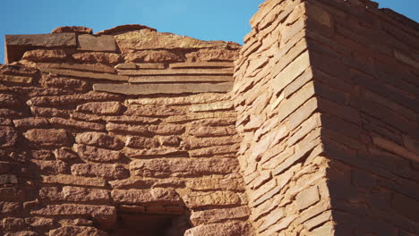 looking up at old ruins of wukoki pueblo on beautiful day