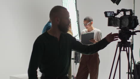 actores que trabajan en el set rodando una película o un video en el estudio con una directora y un camarógrafo de película