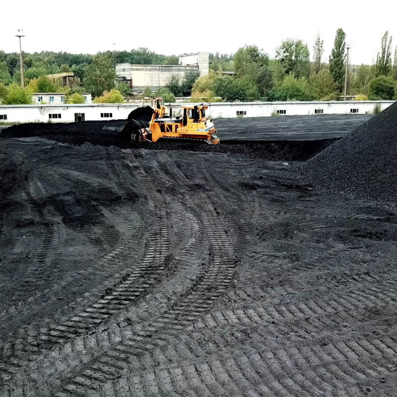 Coal handling operations at the factory. Crawler bulldozer works. Aerial view.
