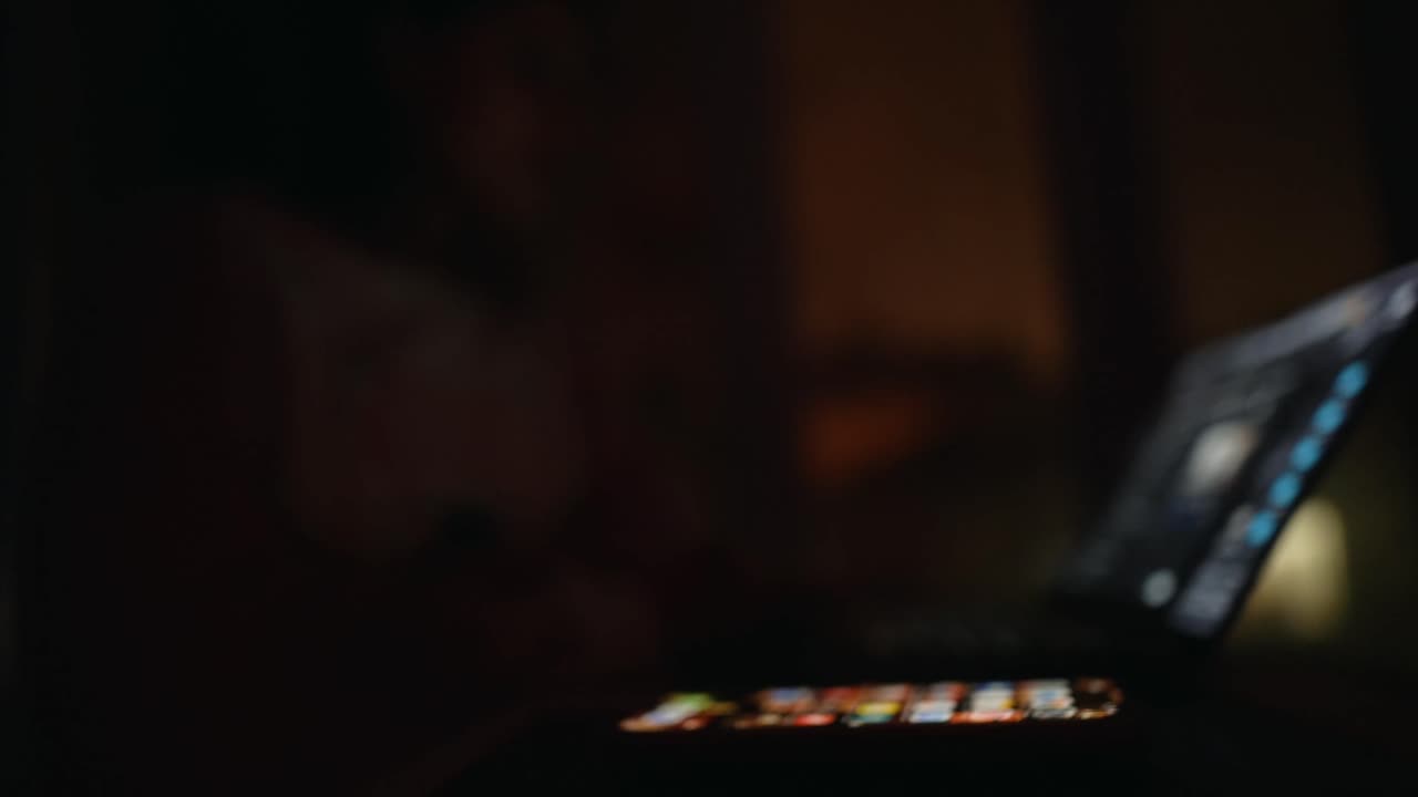 Donna che usa un portatile di notte vicino alla finestra