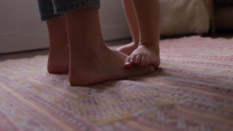 close up view of baby and mother foot at home