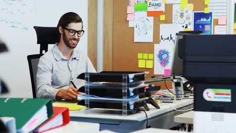 Male-graphic-designer-working-on-graphic-tablet-at-desk