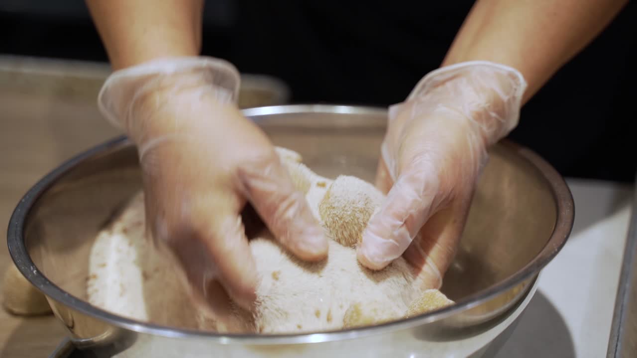 Cookie dough being mixed in a bowl of sugar and cinnamon. 
Taken at a higher frame rate and has been converted to a slow motion video clip.
