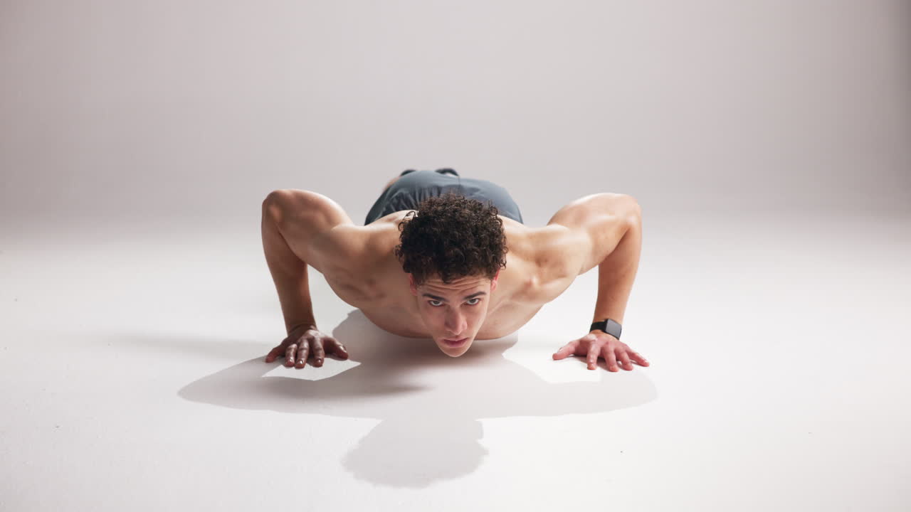 Young Muscular Man Doing Push-ups in a Studio