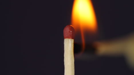 fósforos encendidos a mano primer plano macro capturado frente a fondo negro en cámara lenta a 120 fps