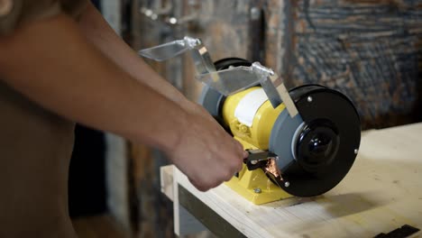 electric sharpener and blade close up, hands cutting knife