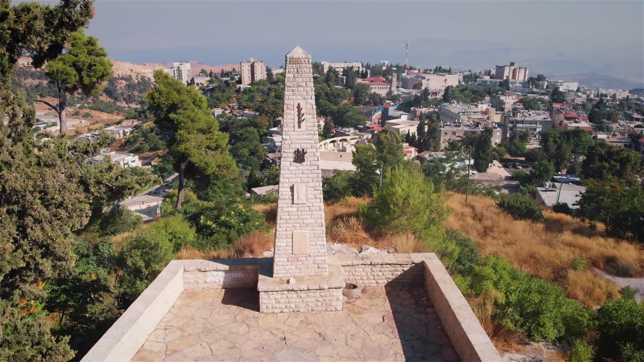 Stone Monument on Hilltop Overlooking City and Valley